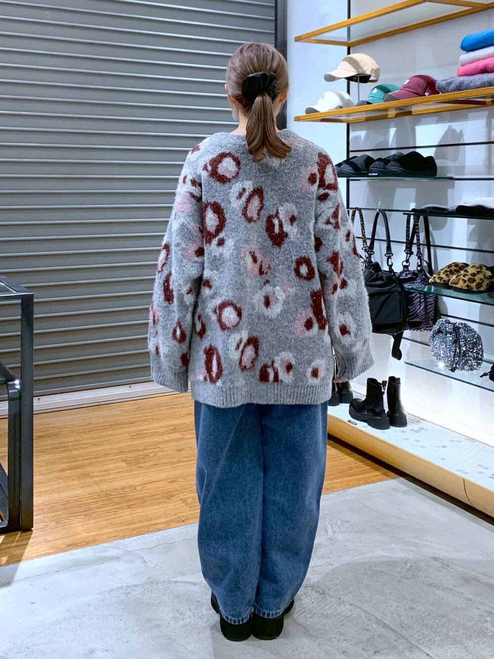 ブラック系のブーツ、ブルー系のデニムパンツ、グレー系のショルダーバッグを着用したレディースの冬コーディネートの2枚目の写真