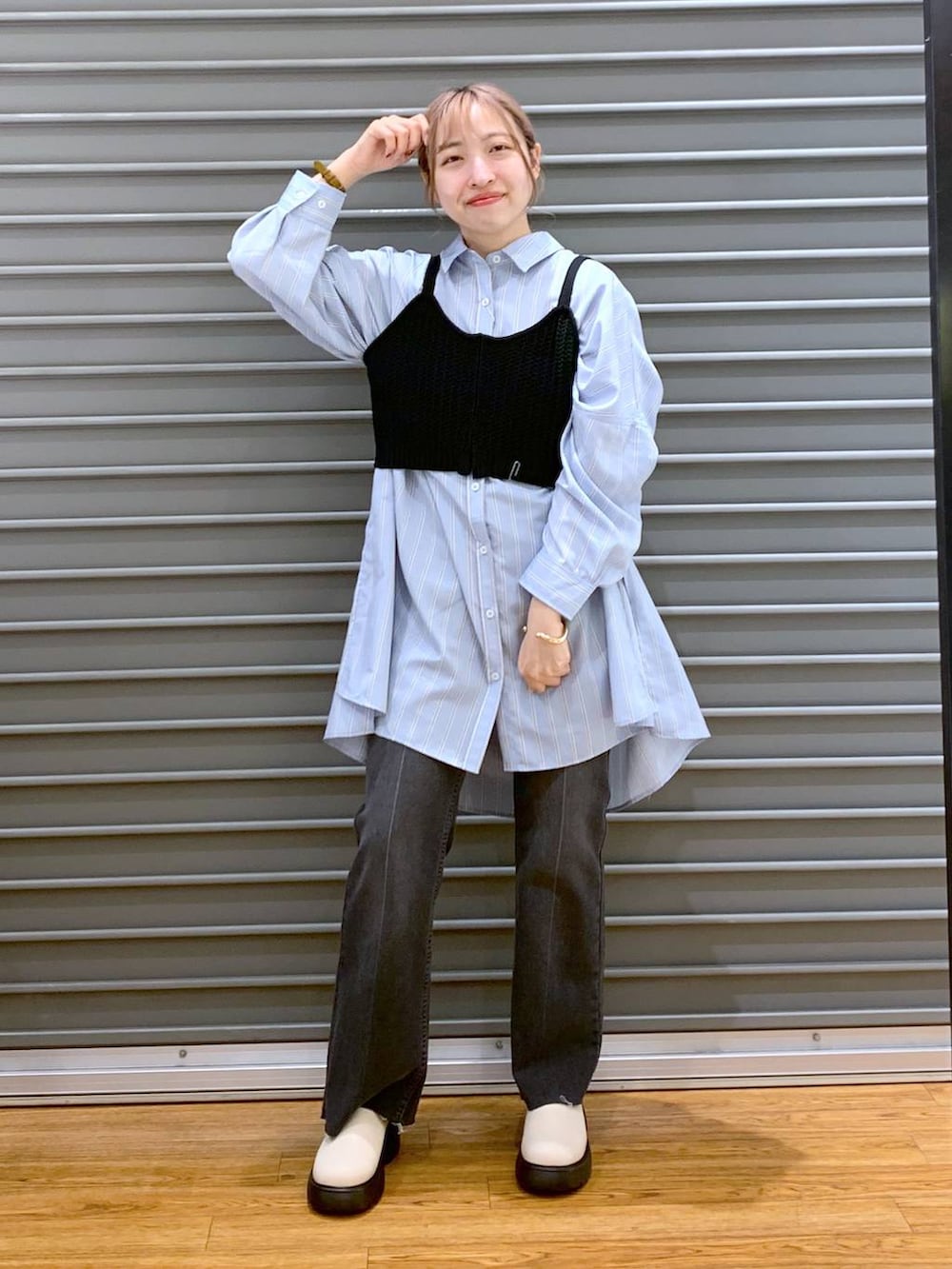 ブラック系のニット/セーター、ブルー系のチュニック、ホワイト系のトートバッグを着用したレディースの春コーディネートの6枚目の写真