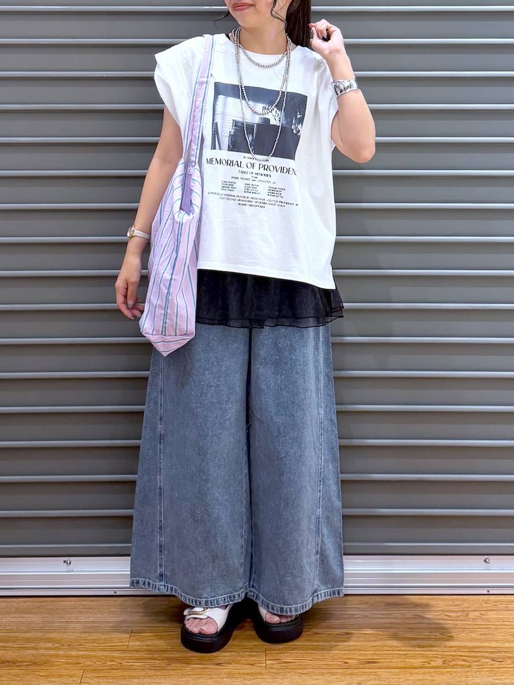 パープル系のトートバッグ、ホワイト系のサンダル、ホワイト系のTシャツ/カットソーを着用したレディースの夏コーディネートの6枚目の写真