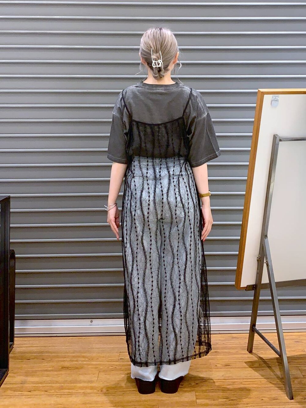 グレー系のTシャツ/カットソー、ブルー系のデニムパンツ、ホワイト系のサンダルを着用したレディースの夏コーディネートの2枚目の写真