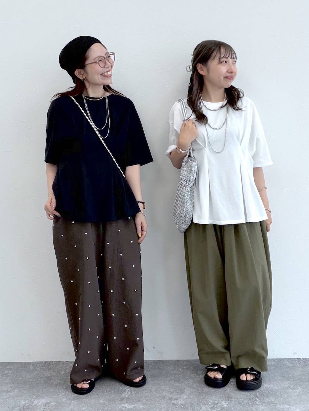 ブラック系のサンダル、グリーン系のその他パンツ、シルバー系のショルダーバッグを着用したレディースの夏コーディネートの4枚目の写真