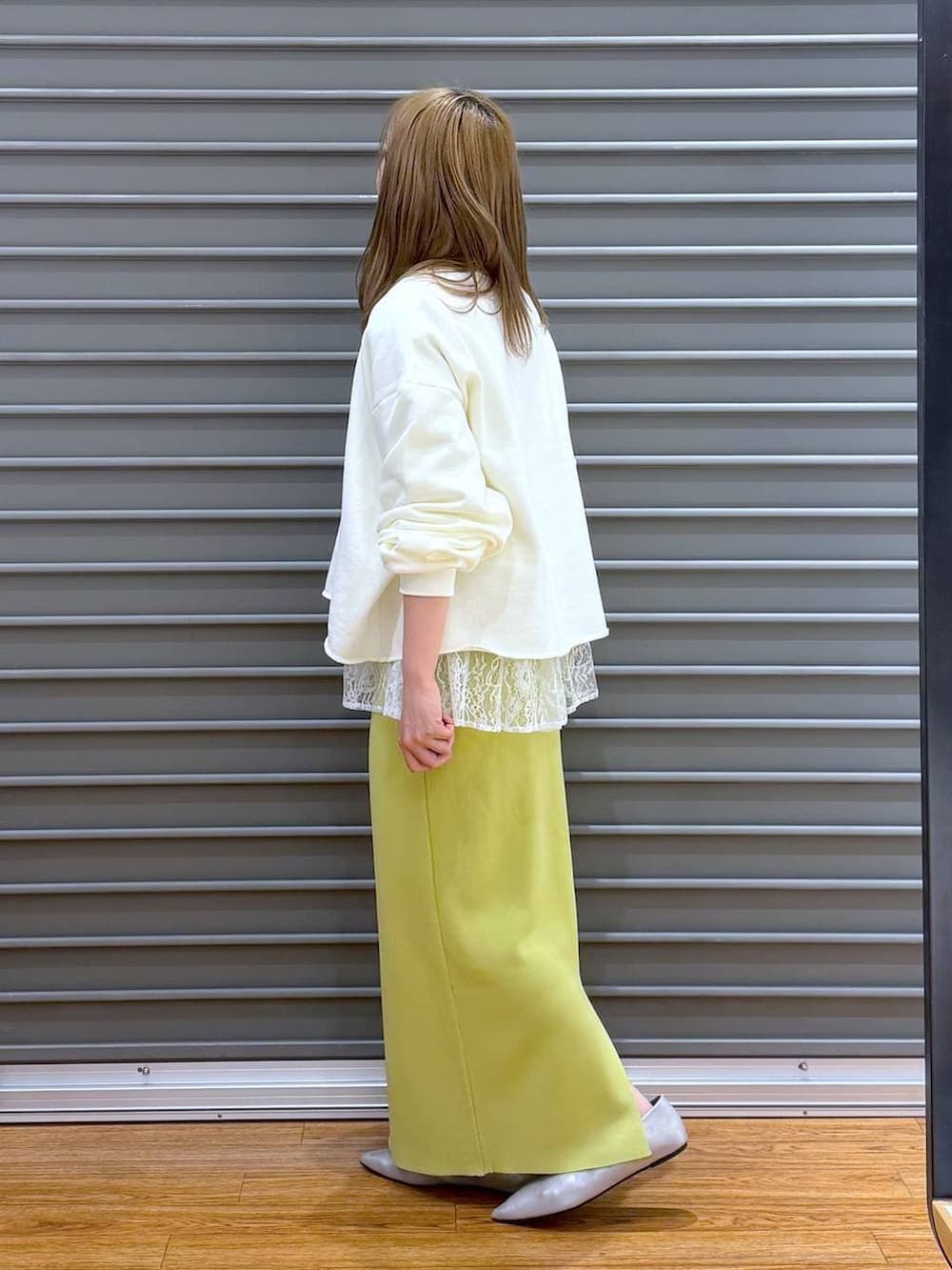 グリーン系のスカート、ホワイト系のTシャツ/カットソー、シルバー系のパンプスを着用したレディースの冬コーディネートの3枚目の写真