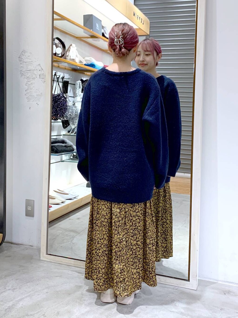 ホワイト系のショルダーバッグ、ホワイト系のブーツ、ブルー系のニット/セーターを着用したレディースの秋コーディネートの2枚目の写真