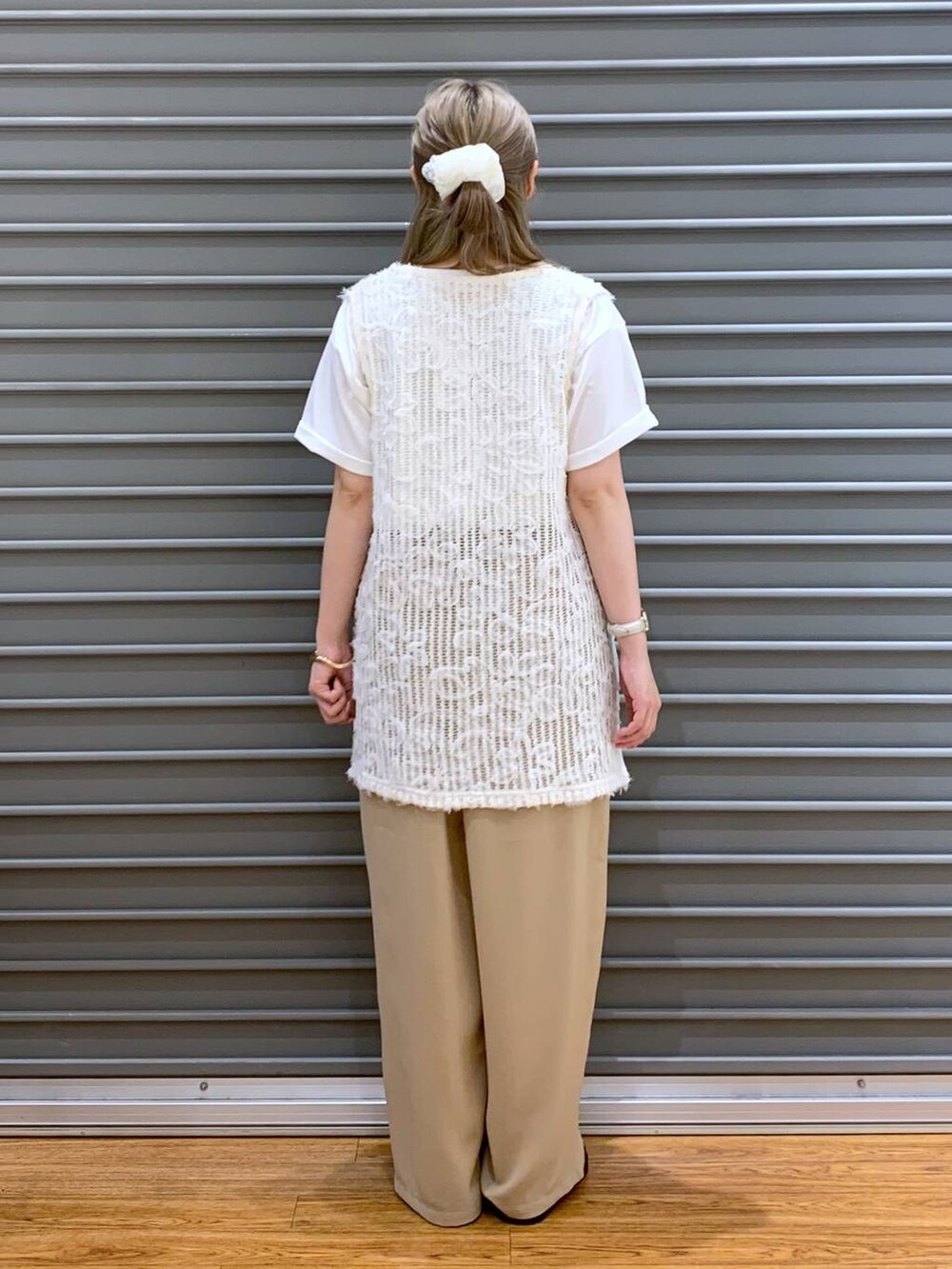 ベージュ系のその他パンツ、ホワイト系のベスト、ホワイト系のサンダルを着用したレディースの春コーディネートの2枚目の写真