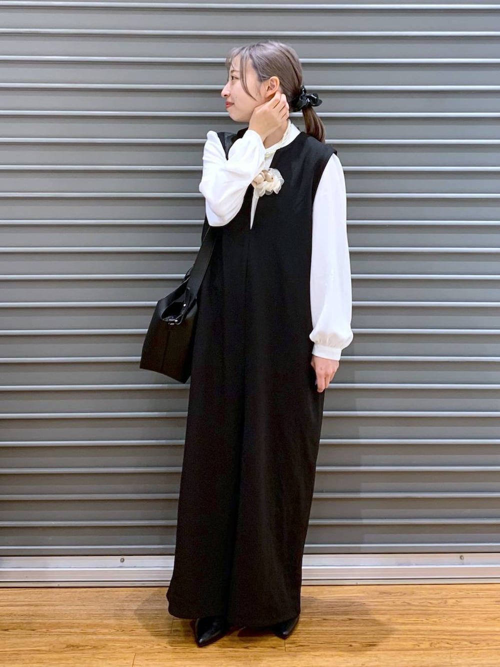 ホワイト系のシャツ/ブラウス、ブラック系のサロペット/オーバーオール、ブラック系のパンプスを着用したレディースの冬コーディネートの6枚目の写真