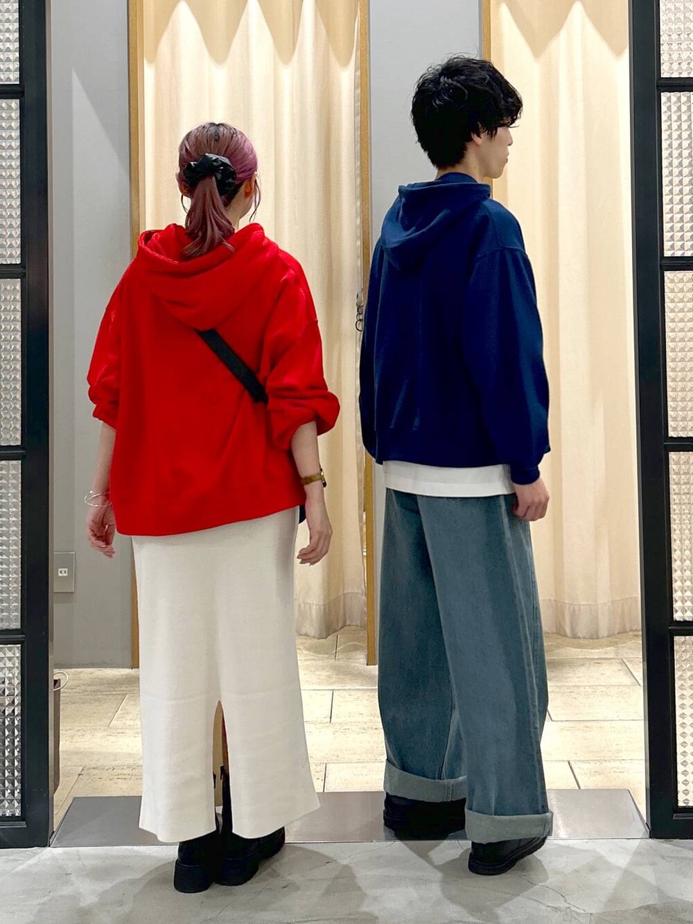 ブラック系のショルダーバッグ、ブルー系のデニムパンツ、ブラック系のブーツを着用したレディースの秋コーディネートの2枚目の写真