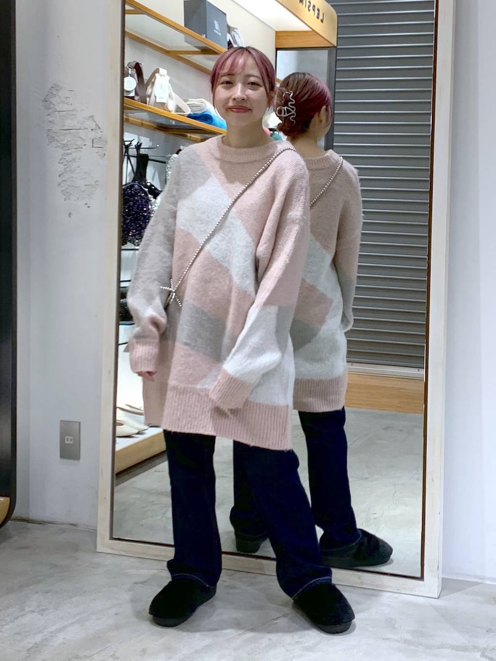 ブルー系のデニムパンツ、ブラック系のダウンジャケット/コート、ブラック系のその他シューズを着用したレディースの冬コーディネートの3枚目の写真