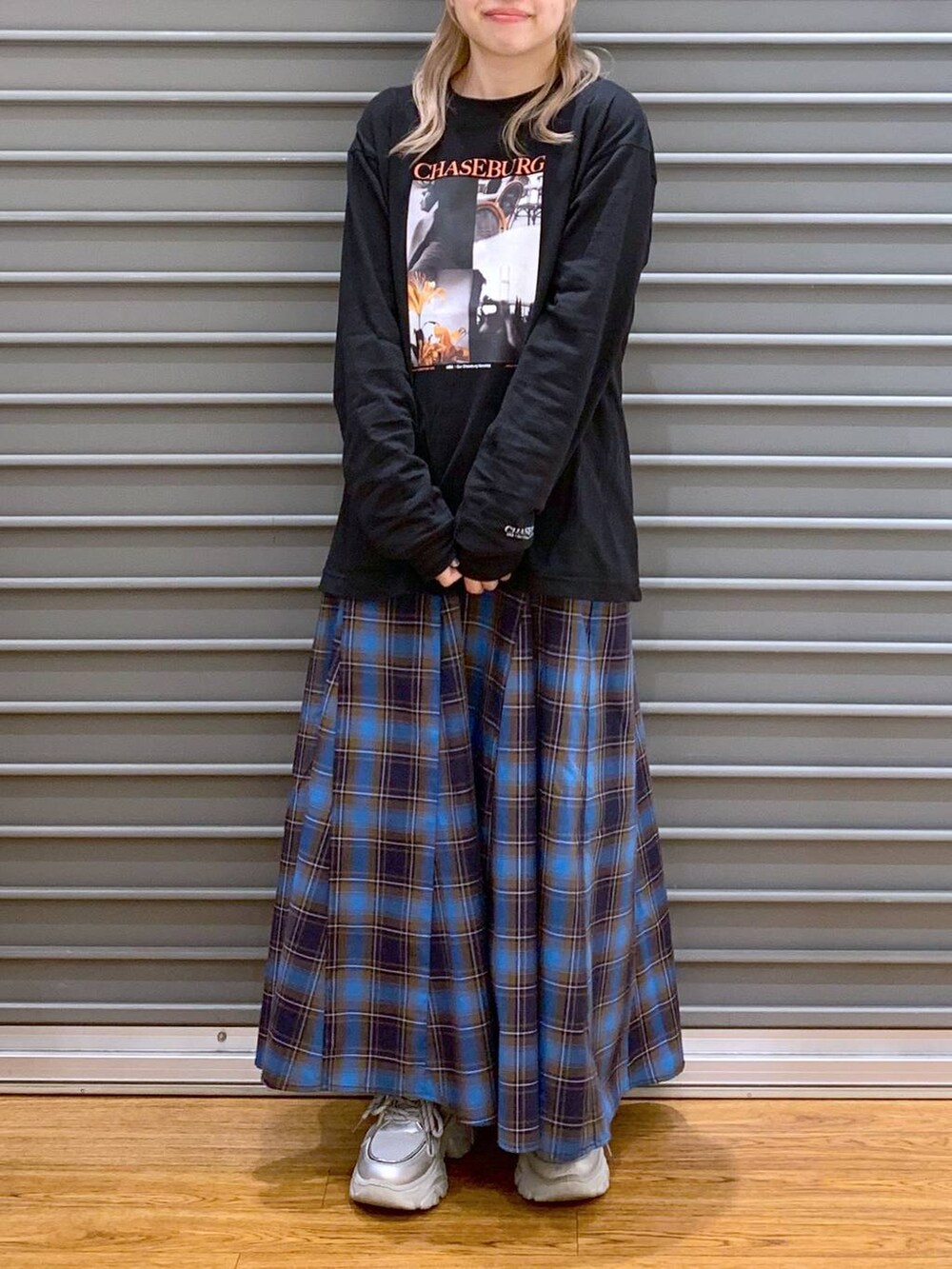 ブラック系のショルダーバッグ、ブラック系のスニーカー、ブルー系のカバーオールを着用したレディースの秋コーディネートの7枚目の写真