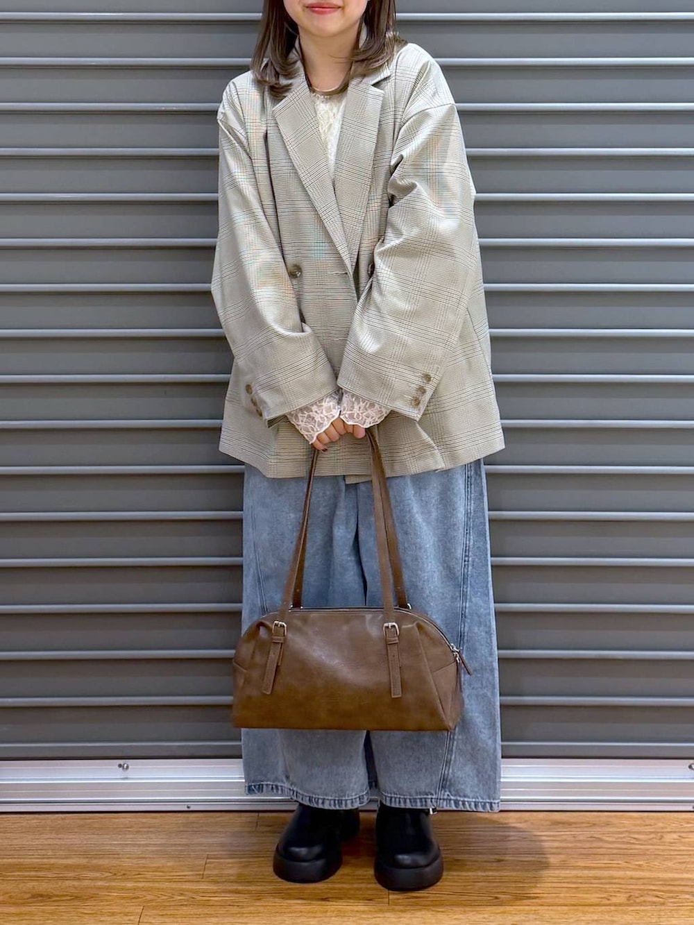 ブラック系のサンダル、ブラウン系のボストンバッグ、ホワイト系のTシャツ/カットソーを着用したレディースの春コーディネートの5枚目の写真