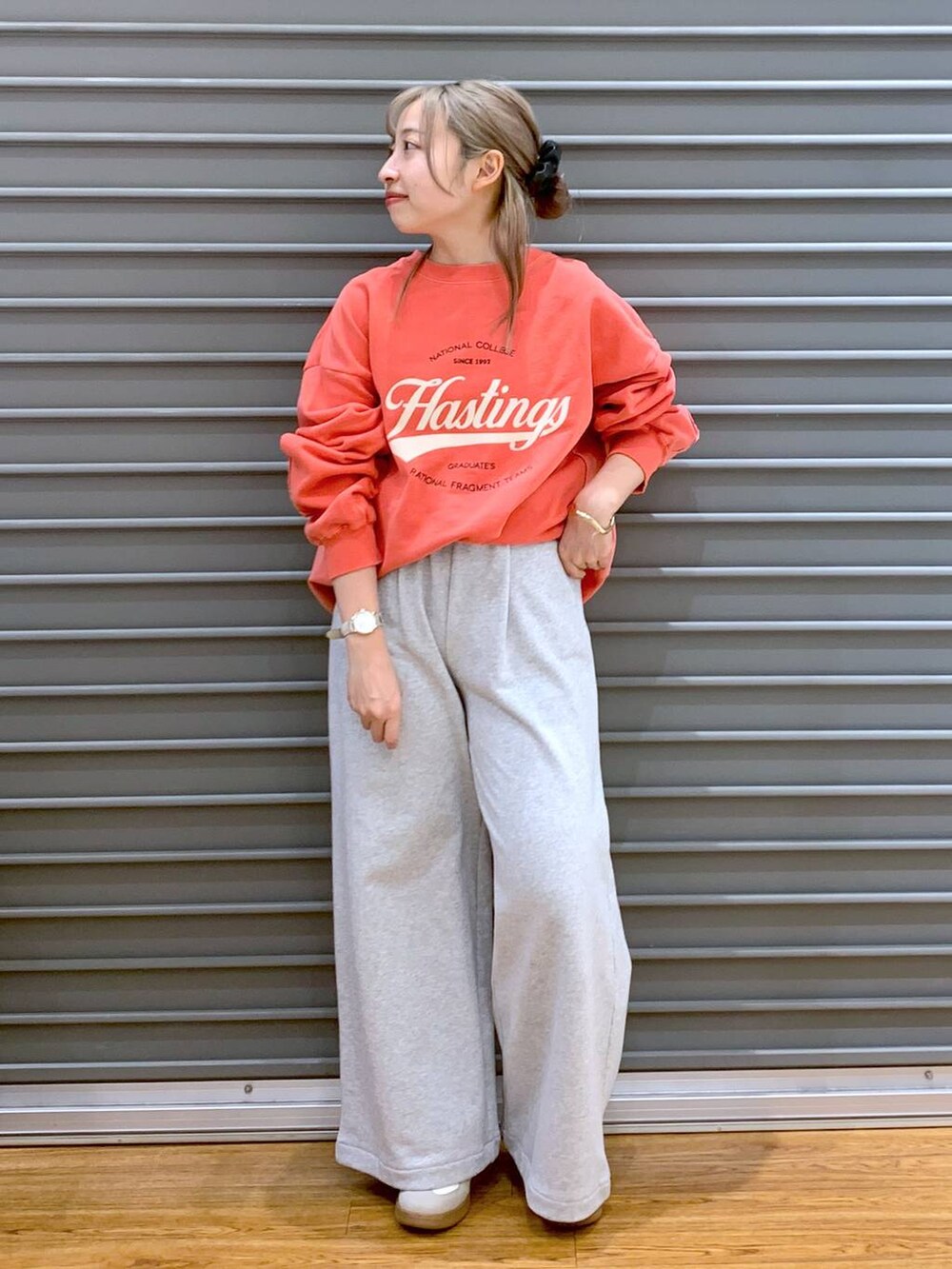 ホワイト系のスニーカー、ブラック系のショルダーバッグ、レッド系のスウェットを着用したレディースの冬コーディネートの3枚目の写真