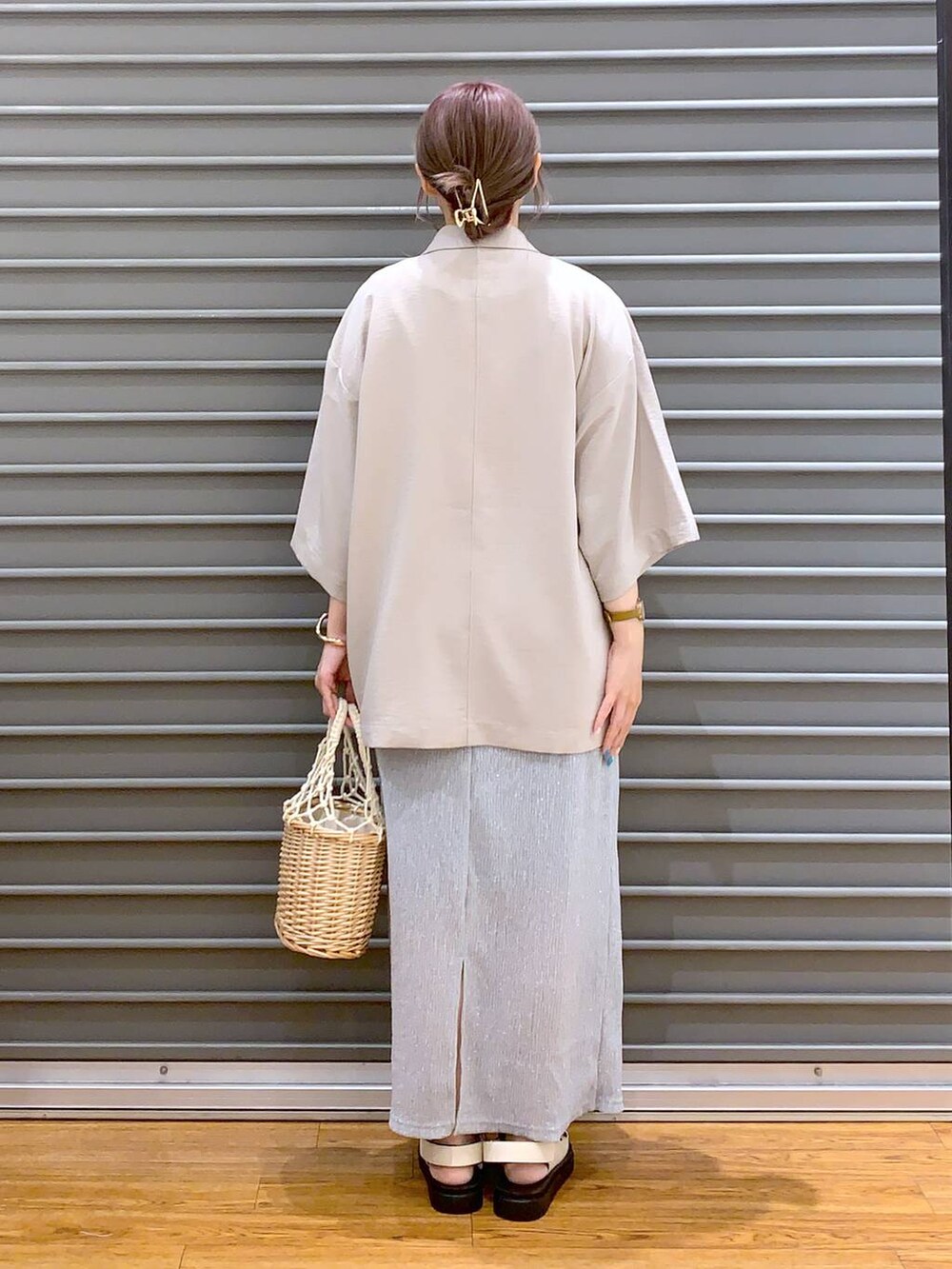 ベージュ系のテーラードジャケット、ホワイト系のサンダル、グレー系のスカートを着用したレディースの夏コーディネートの2枚目の写真