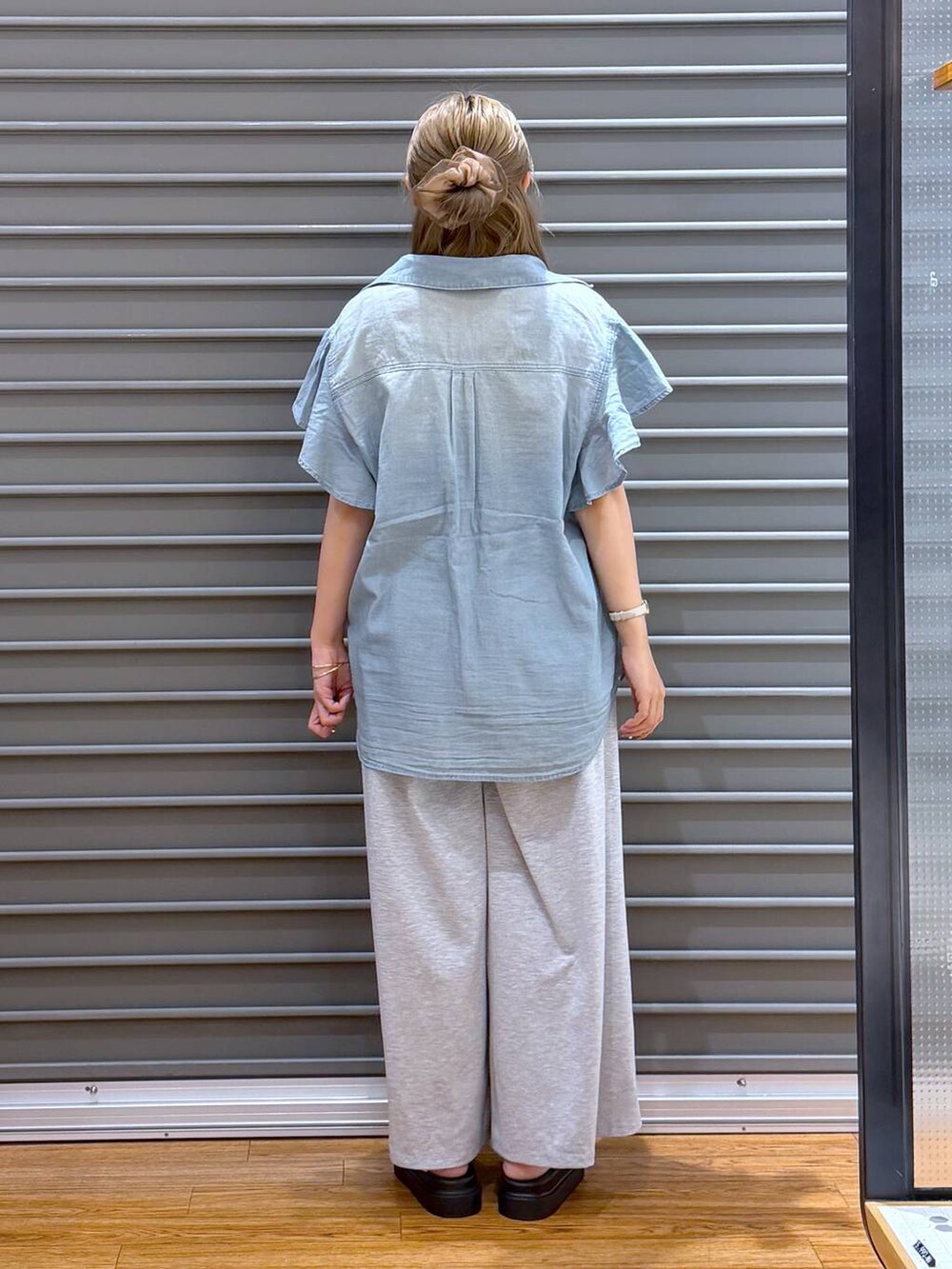グレー系のその他パンツ、ブラック系のショルダーバッグ、ホワイト系のサンダルを着用したレディースの夏コーディネートの2枚目の写真