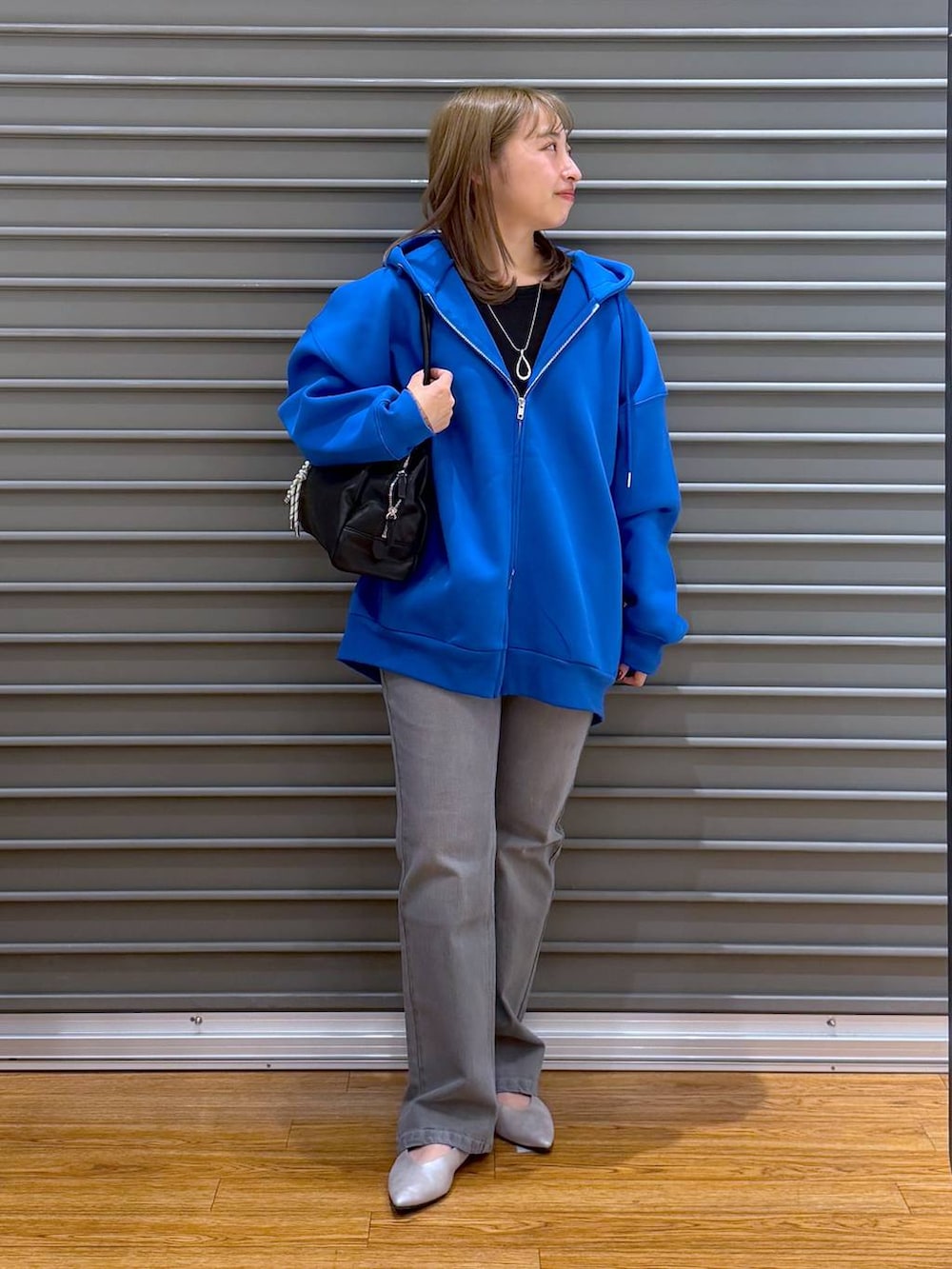 ブルー系のパーカー、ブラック系のTシャツ/カットソー、シルバー系のパンプスを着用したレディースの春コーディネートの4枚目の写真