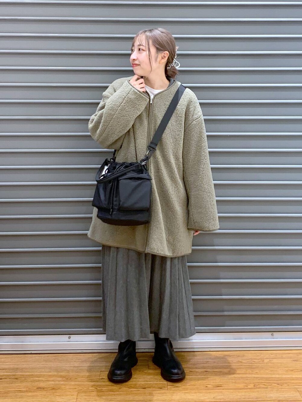 ブラック系のショルダーバッグ、グリーン系のその他アウター、ブラック系のブーツを着用したレディースの冬コーディネートの5枚目の写真