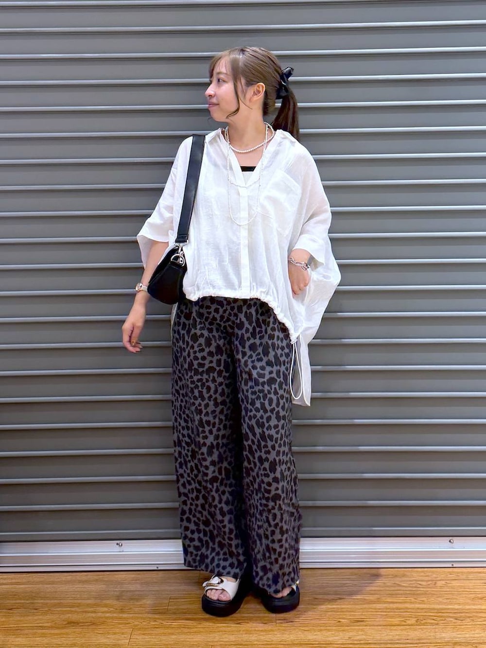ホワイト系のシャツ/ブラウス、グレー系のその他パンツ、ブラック系のショルダーバッグを着用したレディースの夏コーディネートの4枚目の写真