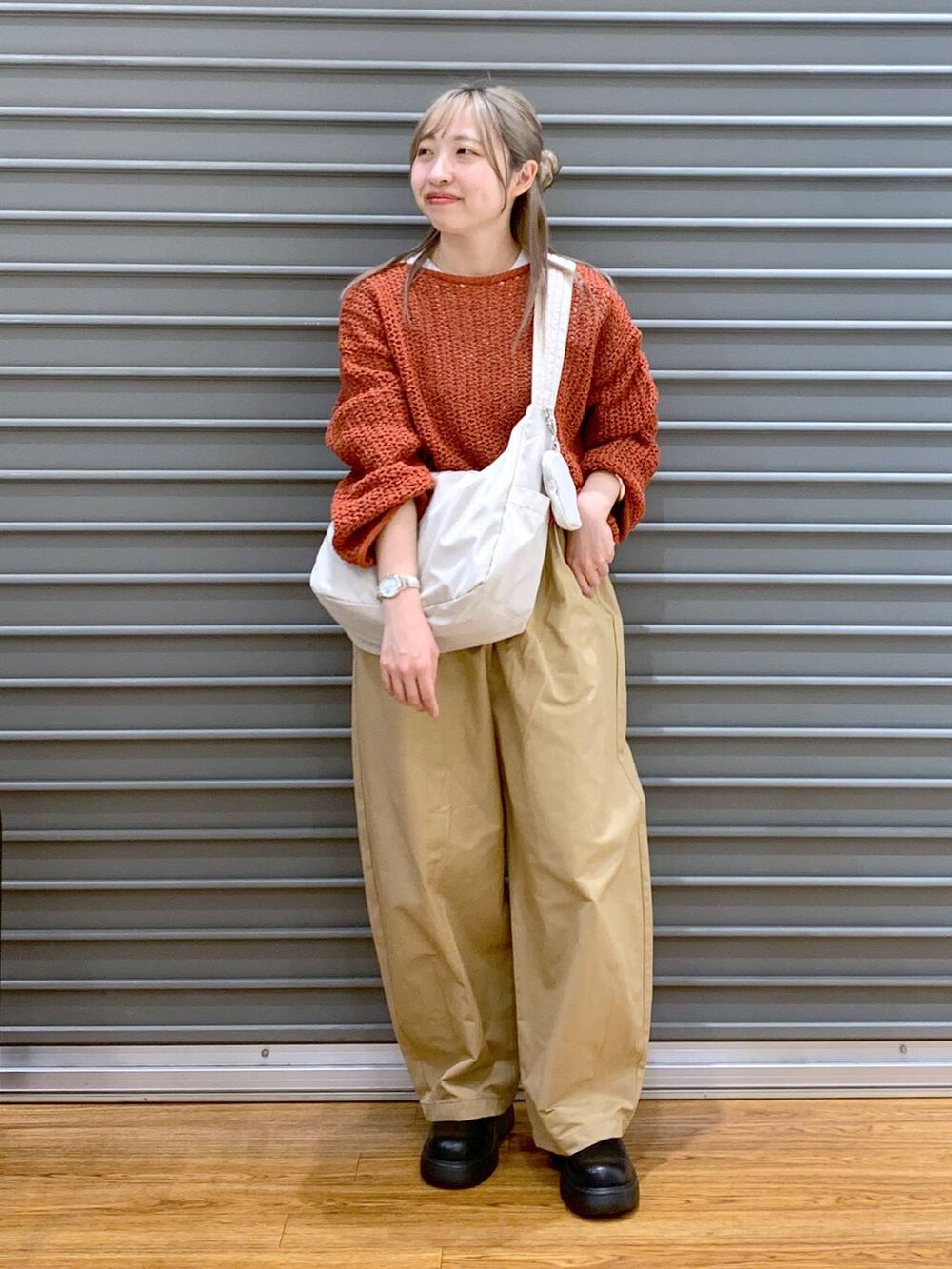 レッド系のニット/セーター、ホワイト系のショルダーバッグ、ブラック系のサンダルを着用したレディースの春コーディネートの6枚目の写真