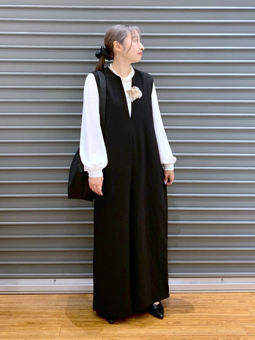 ホワイト系のシャツ/ブラウス、ブラック系のサロペット/オーバーオール、ブラック系のパンプスを着用したレディースの冬コーディネートの5枚目の写真