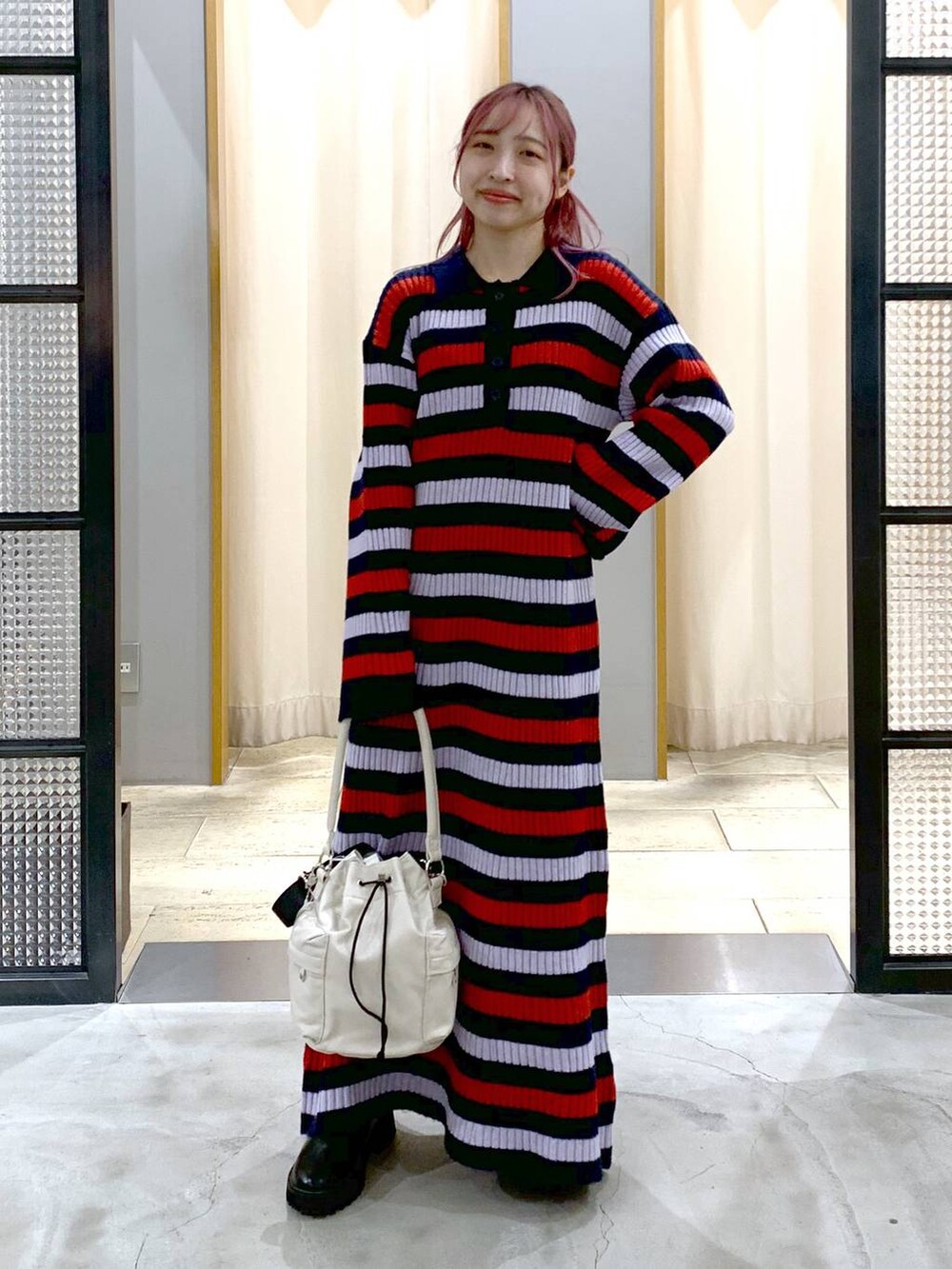 ブラック系のブーツ、ホワイト系のショルダーバッグ、その他のワンピースを着用したレディースの秋コーディネートの4枚目の写真