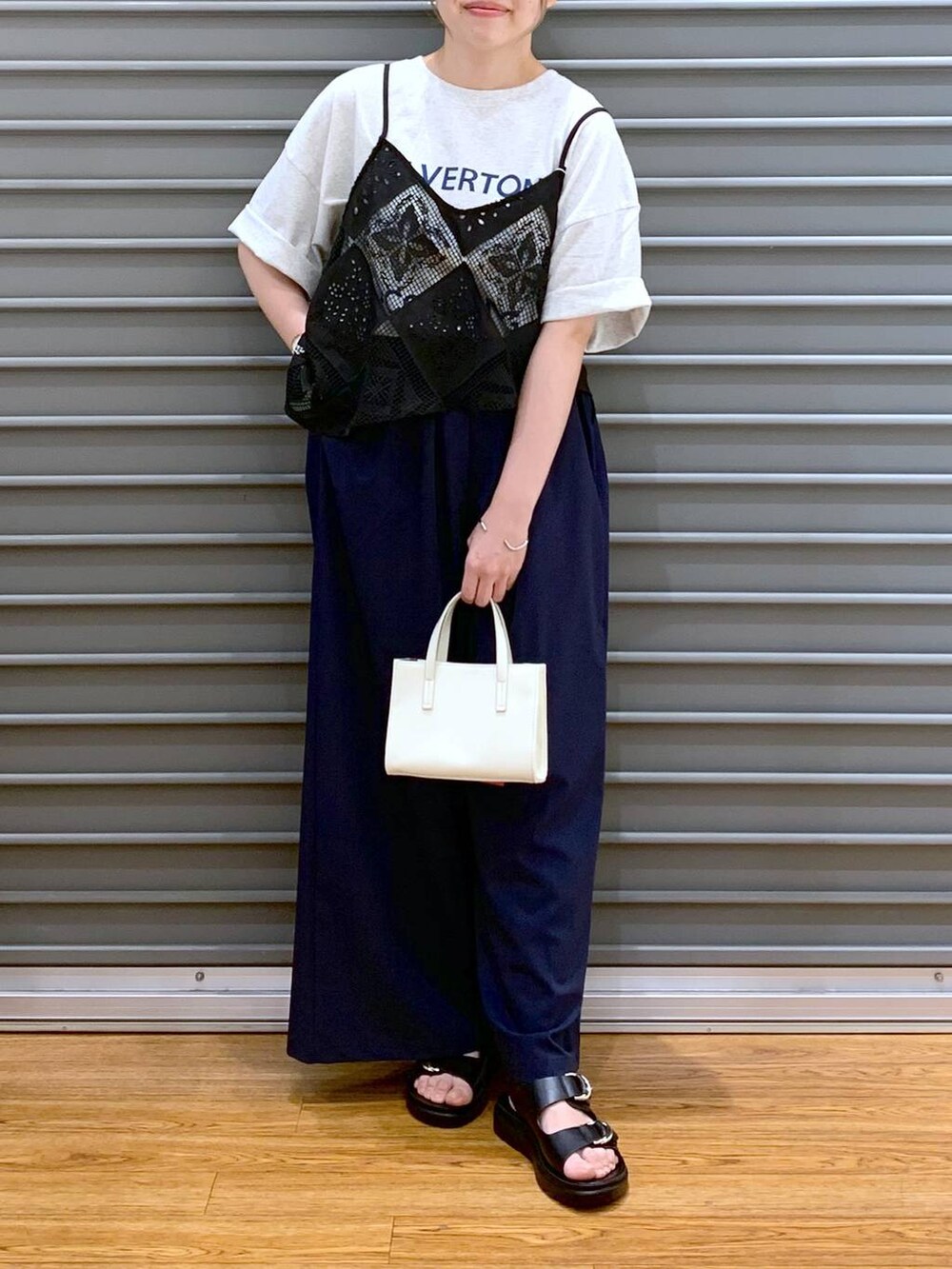 ブラック系のサンダル、ブルー系のその他パンツ、ホワイト系のショルダーバッグを着用したレディースの夏コーディネートの4枚目の写真