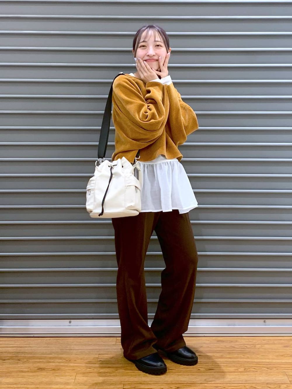 ブラック系のブーツ、ホワイト系のTシャツ/カットソー、ホワイト系のショルダーバッグを着用したレディースの冬コーディネートの5枚目の写真