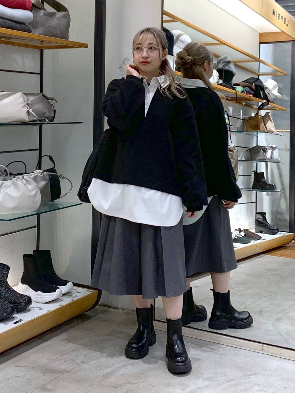 ブラック系のブーツ、ブラック系のトートバッグ、グレー系のその他パンツを着用したレディースの冬コーディネートの6枚目の写真