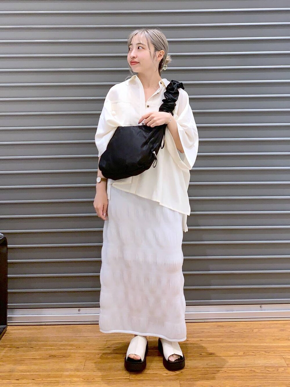 ブラック系のショルダーバッグ、ホワイト系のサンダル、ホワイト系のシャツ/ブラウスを着用したレディースの夏コーディネートの5枚目の写真