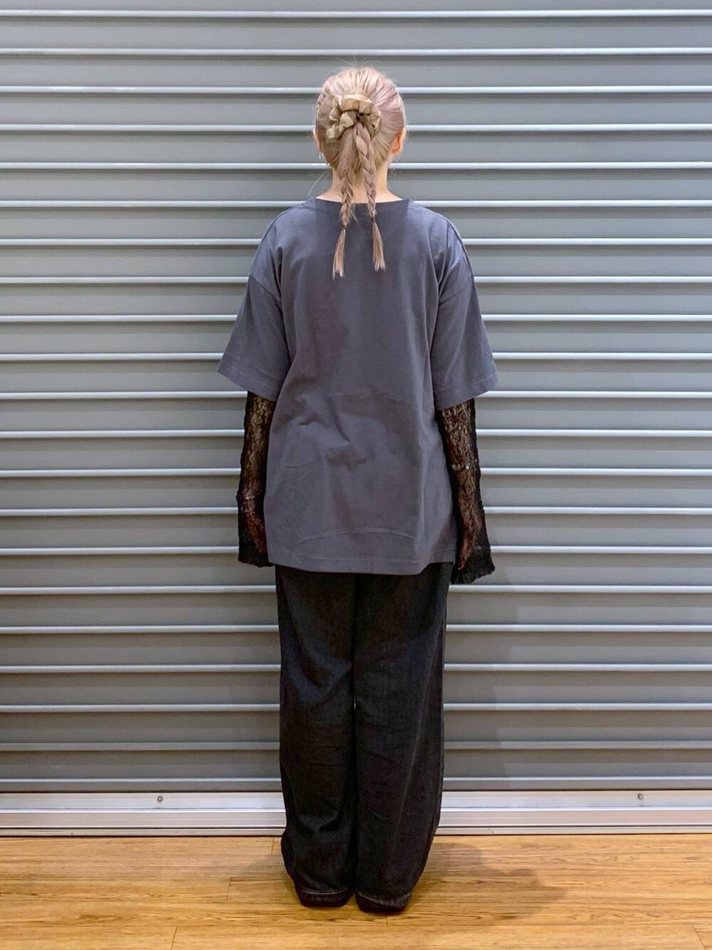 ブラック系のデニムパンツ、ブラック系のスニーカー、ブラック系のショルダーバッグを着用したレディースの秋コーディネートの2枚目の写真