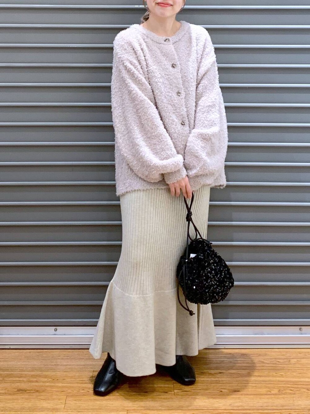 ブラック系のショルダーバッグ、ブラック系のブーツ、ホワイト系のワンピースを着用したレディースの冬コーディネートの7枚目の写真