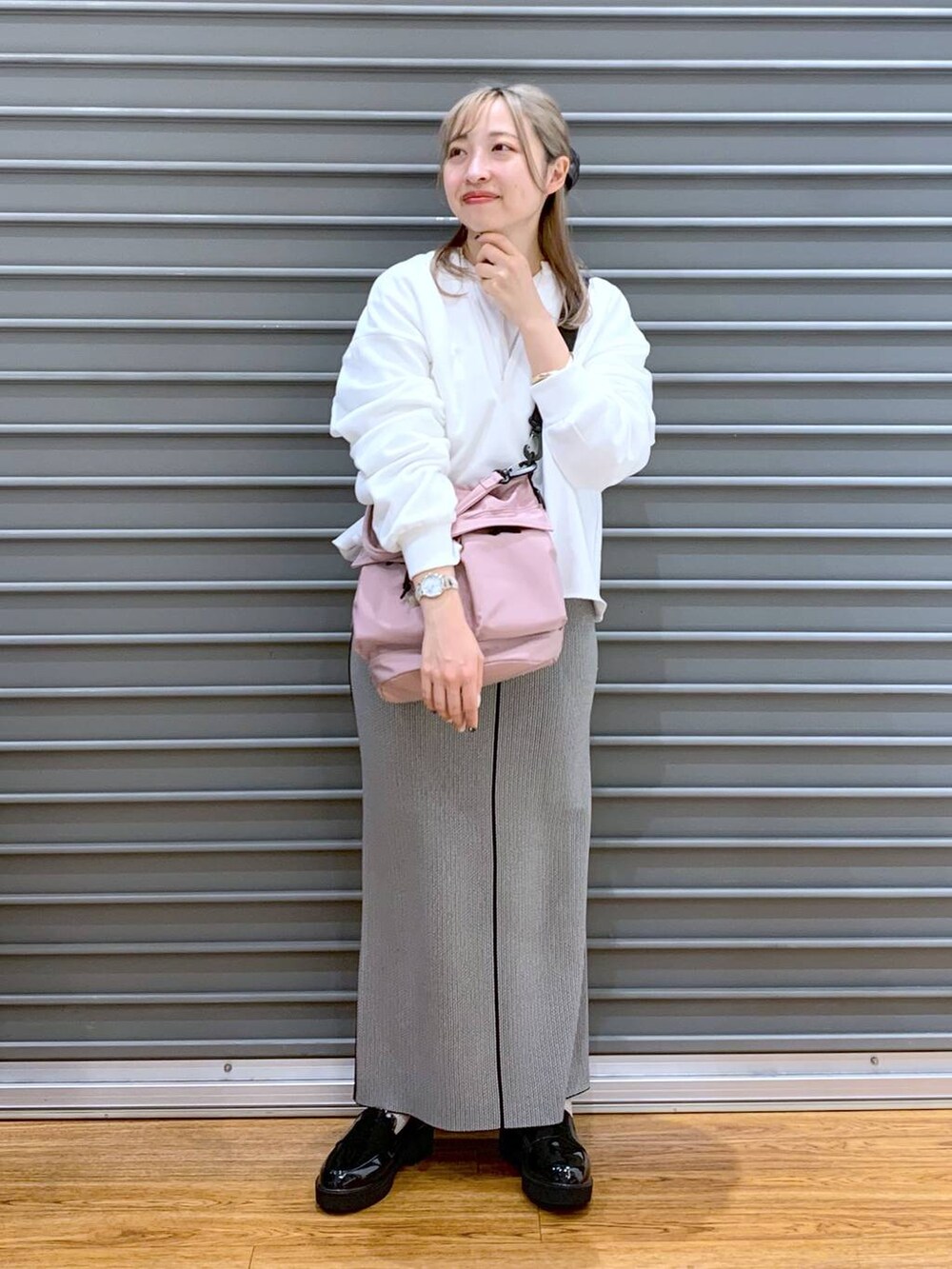 ピンク系のショルダーバッグ、ブラック系のローファー、ブラック系のスカートを着用したレディースの春コーディネートの6枚目の写真