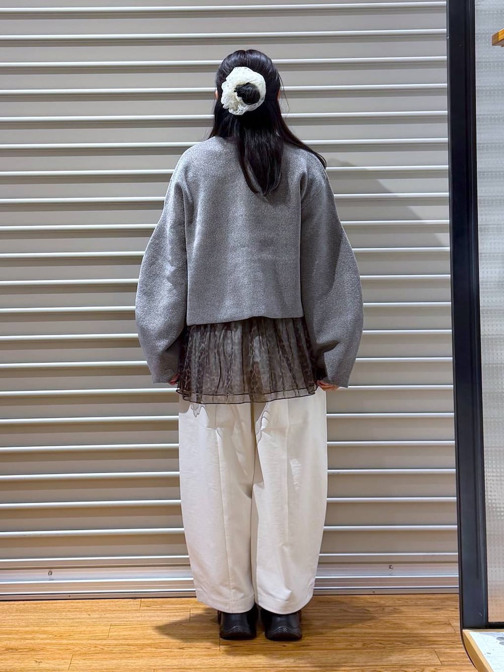 ブラック系のショルダーバッグ、ブラック系のスニーカー、ブラック系のTシャツ/カットソーを着用したレディースの秋コーディネートの2枚目の写真