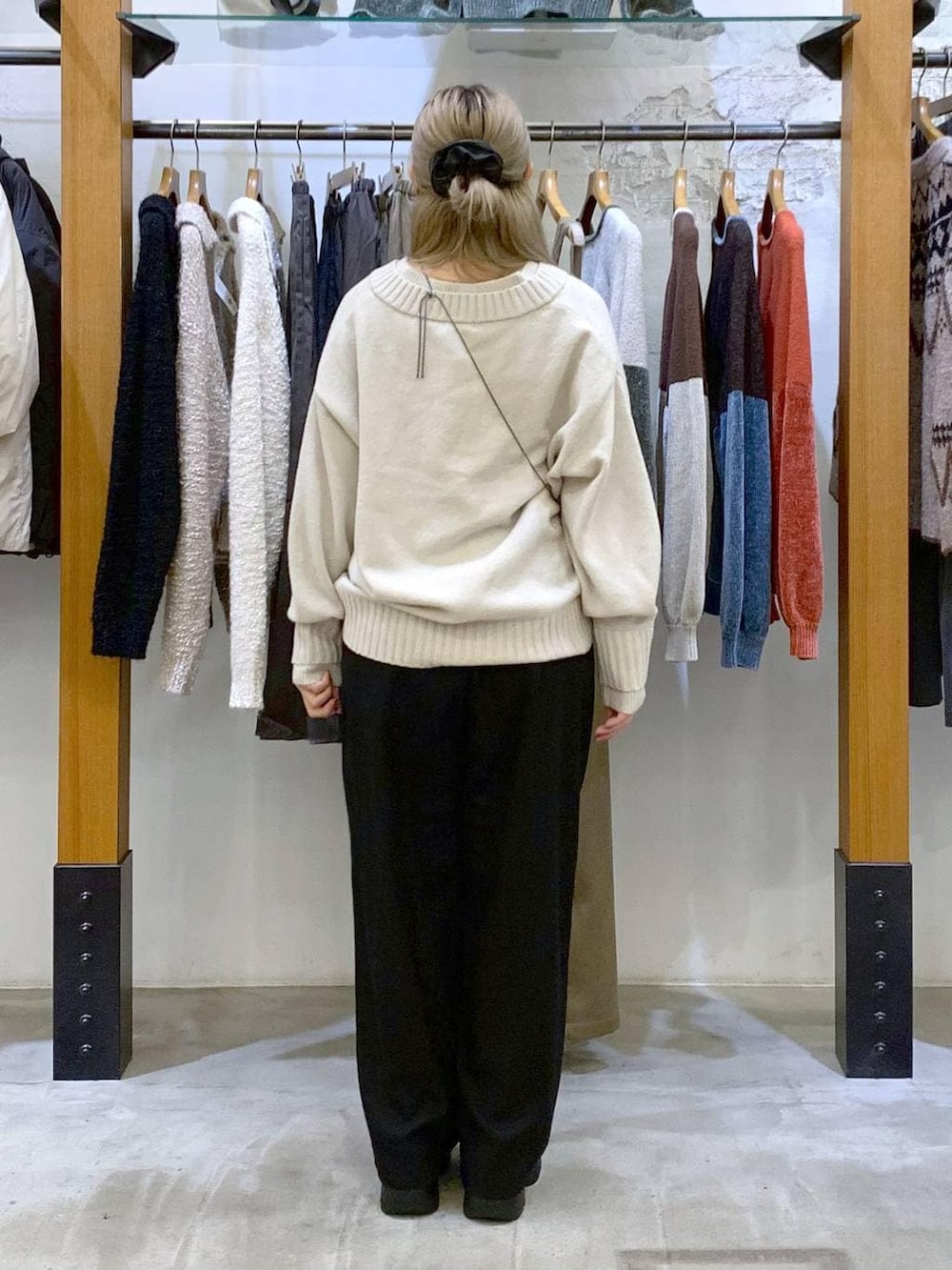 ブラック系のその他パンツ、ホワイト系のニット/セーター、ブラック系のブーツを着用したレディースの冬コーディネートの2枚目の写真