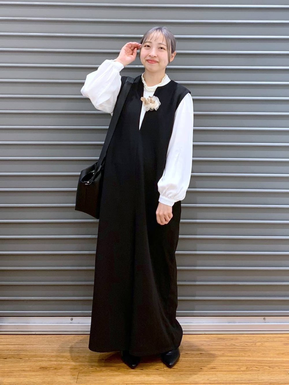 ホワイト系のシャツ/ブラウス、ブラック系のサロペット/オーバーオール、ブラック系のパンプスを着用したレディースの冬コーディネートの7枚目の写真