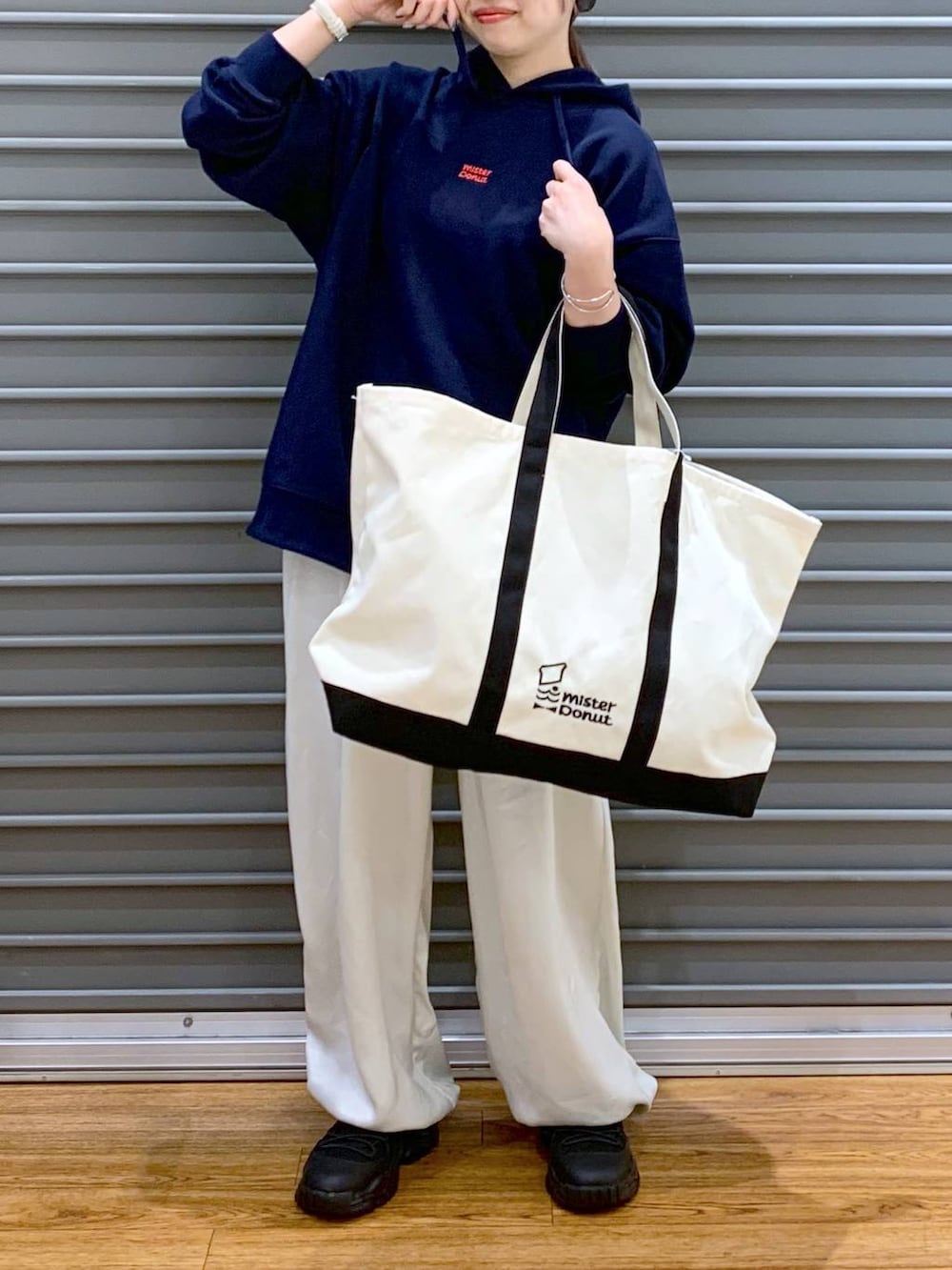 ブラック系のスニーカー、ホワイト系のその他パンツ、ホワイト系のトートバッグを着用したレディースの冬コーディネートの6枚目の写真