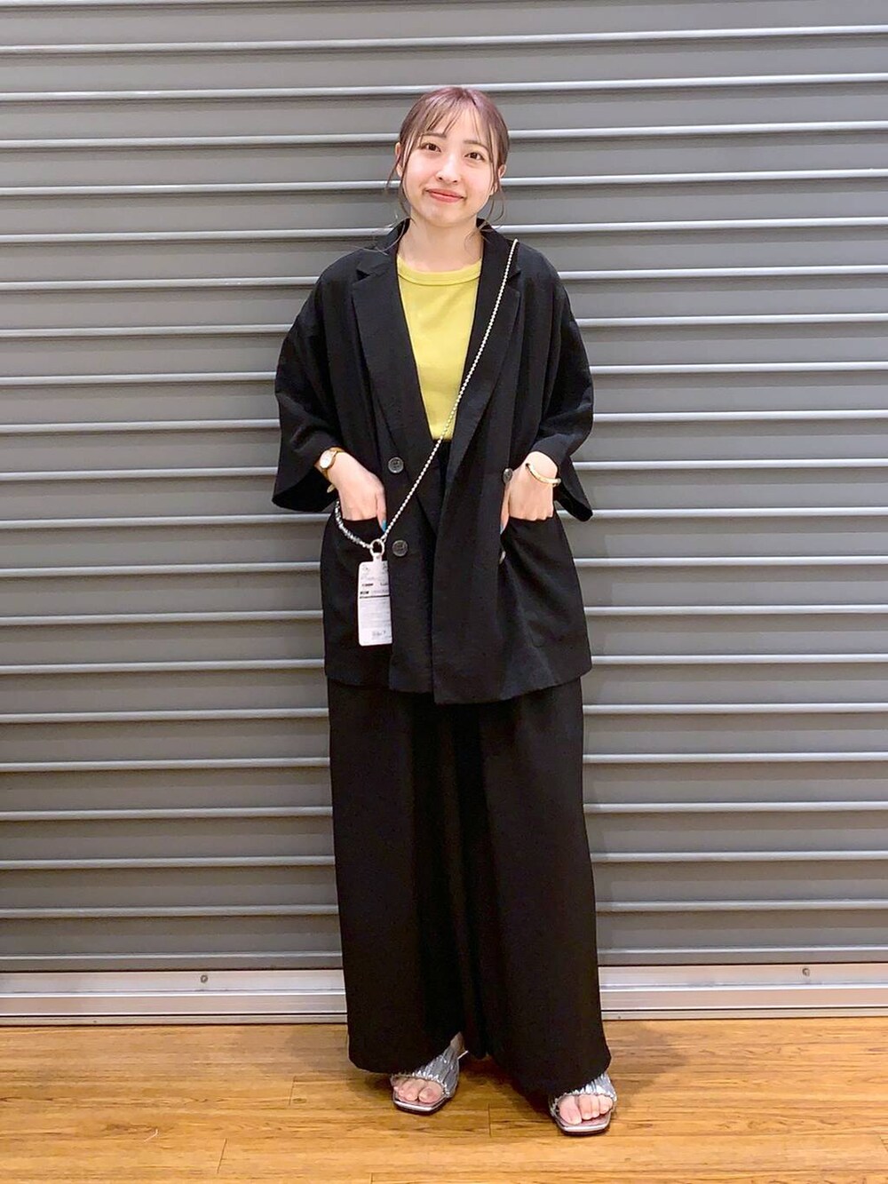 ブラック系のその他パンツ、ブラック系のテーラードジャケット、イエロー系のタンクトップを着用したレディースの夏コーディネートの4枚目の写真