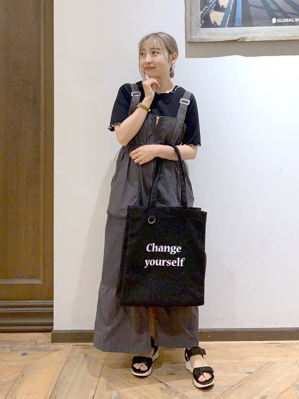 ブラック系のトートバッグ、ブラック系のサンダル、ブラック系のTシャツ/カットソーを着用したレディースの夏コーディネートの2枚目の写真