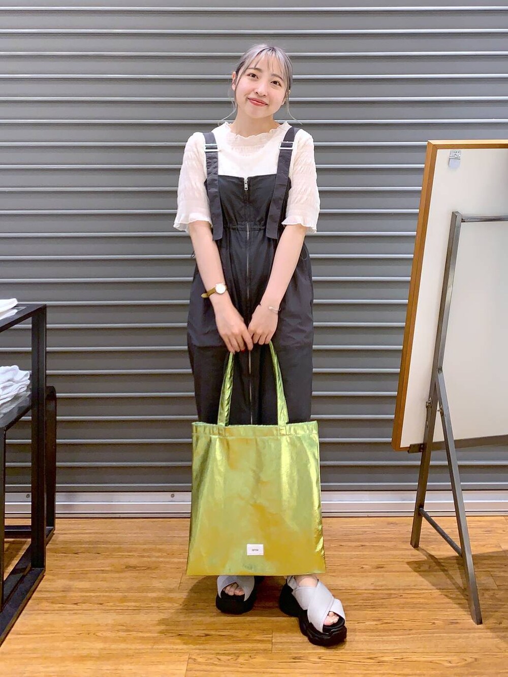 ホワイト系のTシャツ/カットソー、グリーン系のトートバッグ、ホワイト系のサンダルを着用したレディースの夏コーディネートの5枚目の写真