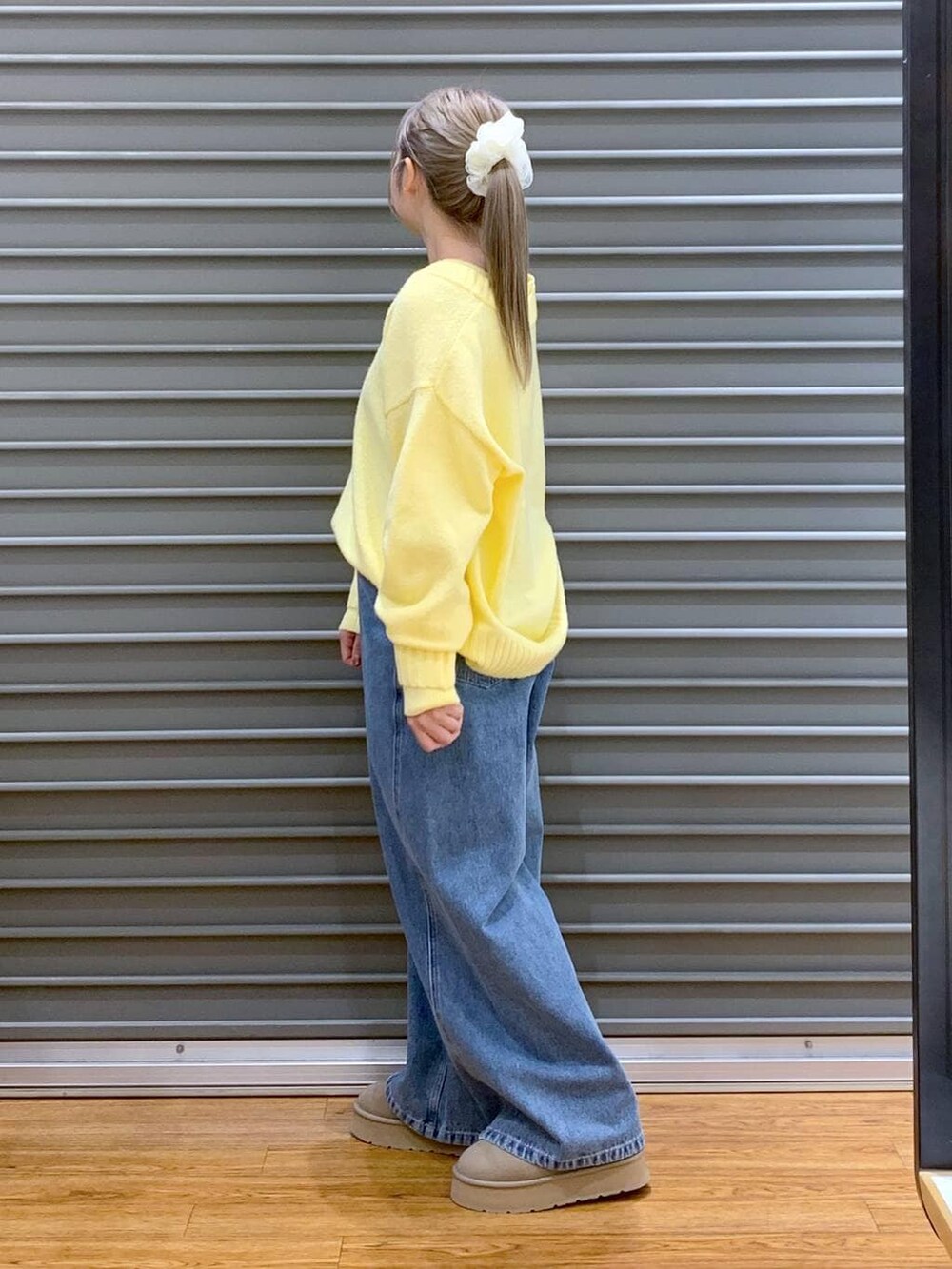 イエロー系のニット/セーター、ブラック系のブルゾン、ブラック系のトートバッグを着用したレディースの冬コーディネートの5枚目の写真