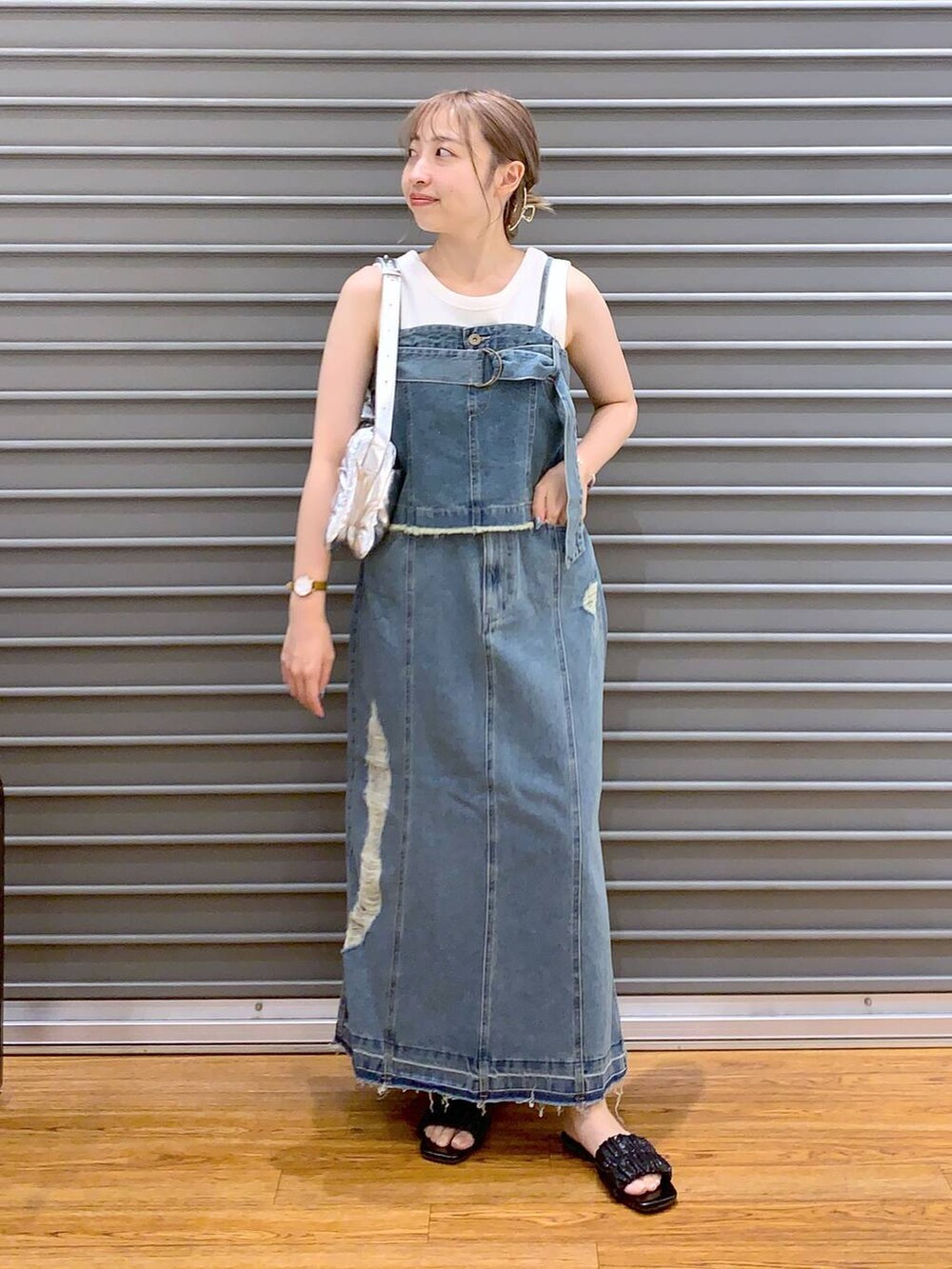 シルバー系のショルダーバッグ、ブラック系のサンダル、ホワイト系のタンクトップを着用したレディースの夏コーディネートの3枚目の写真