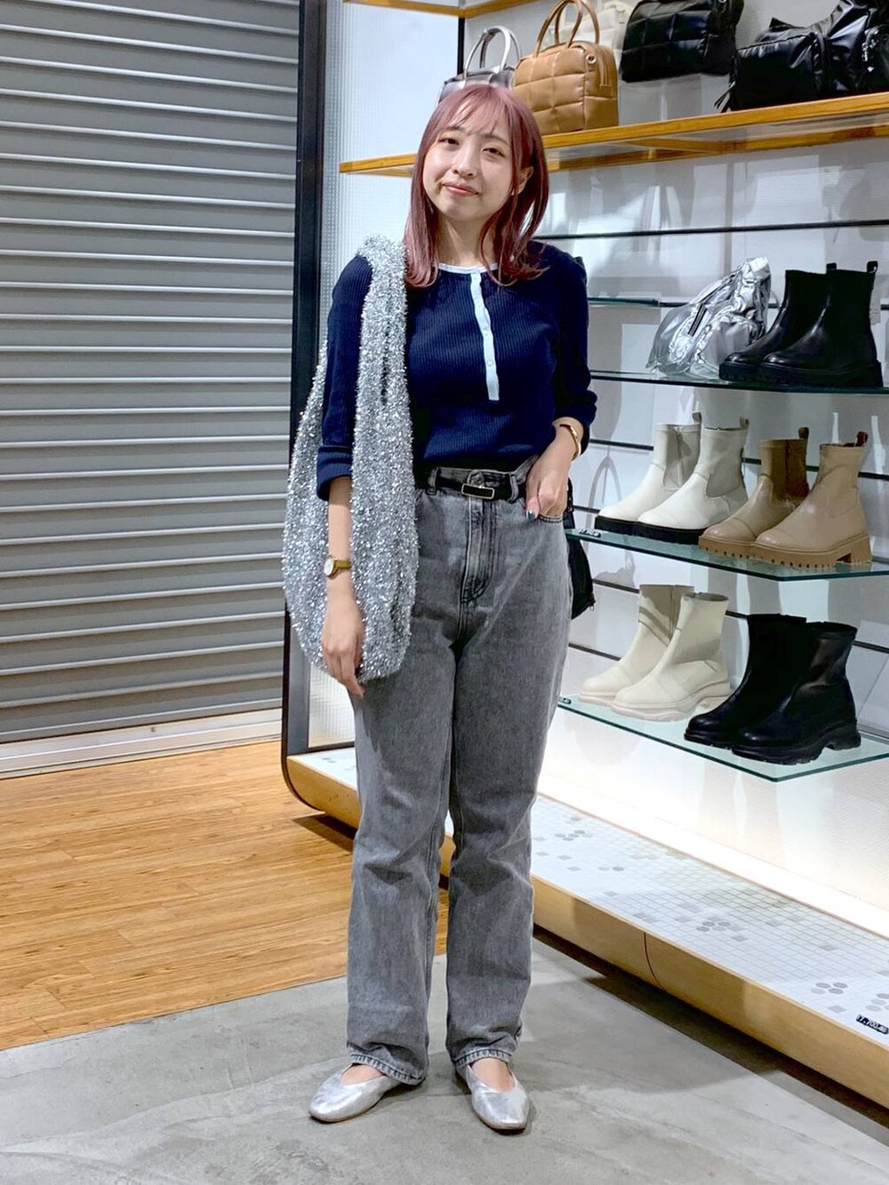 シルバー系のショルダーバッグ、シルバー系のパンプス、グレー系のデニムパンツを着用したレディースの秋コーディネートの5枚目の写真