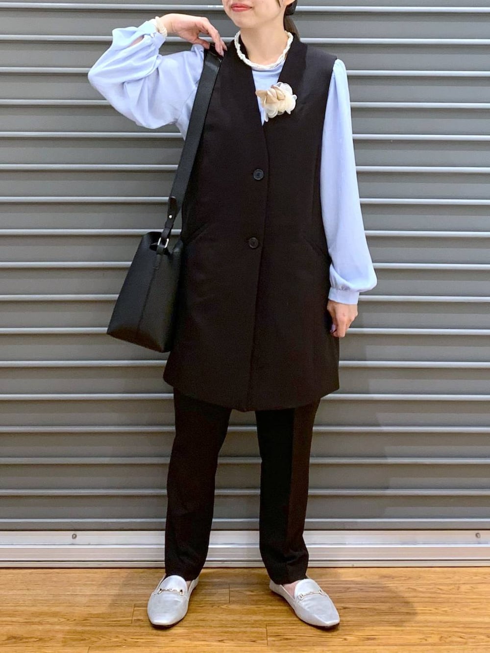 ブラック系のスーツパンツ、ブルー系のシャツ/ブラウス、ブラック系のスーツベストを着用したレディースの冬コーディネートの8枚目の写真