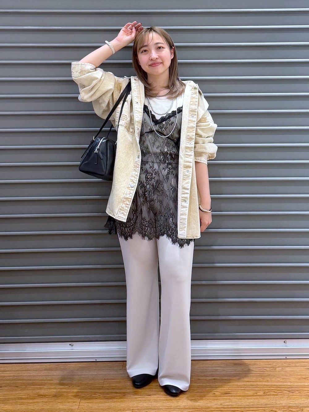 ブラック系のボストンバッグ、ホワイト系のTシャツ/カットソー、ベージュ系のシャツ/ブラウスを着用したレディースの春コーディネートの5枚目の写真