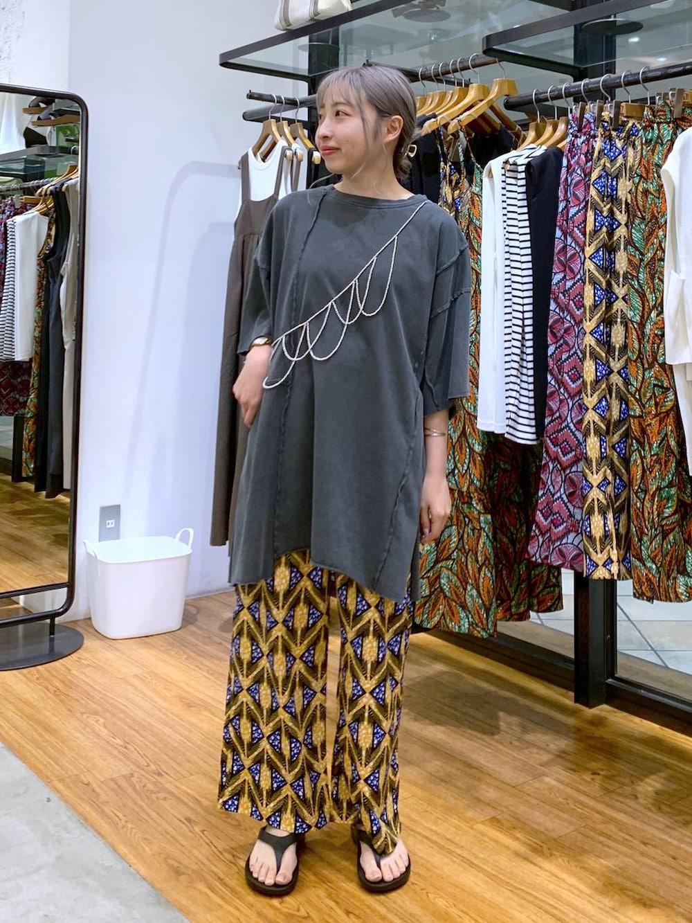 ブラック系のサンダル、グレー系のチュニック、オレンジ系のその他パンツを着用したレディースの夏コーディネートの6枚目の写真