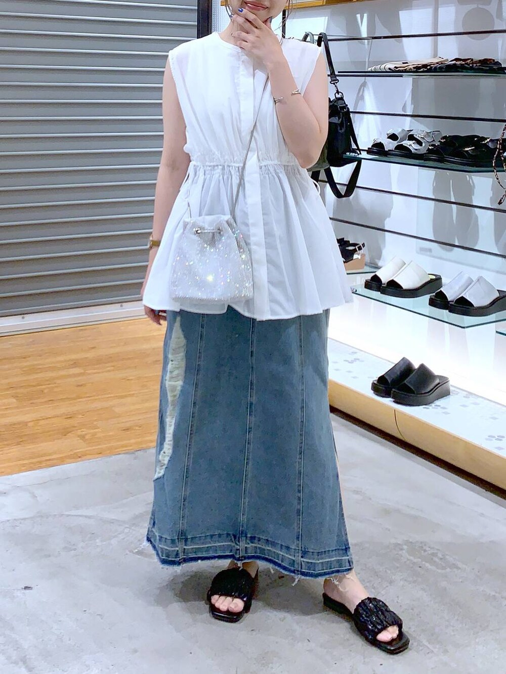 ホワイト系のショルダーバッグ、ブラック系のサンダル、ブルー系のスカートを着用したレディースの夏コーディネートの4枚目の写真
