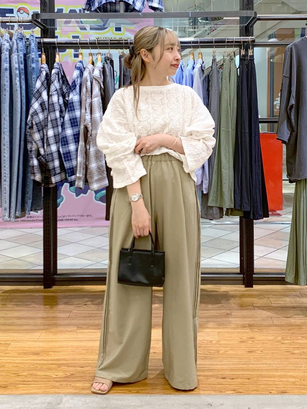 ブラック系のショルダーバッグ、ベージュ系のその他パンツ、ホワイト系のTシャツ/カットソーを着用したレディースの春コーディネートの6枚目の写真