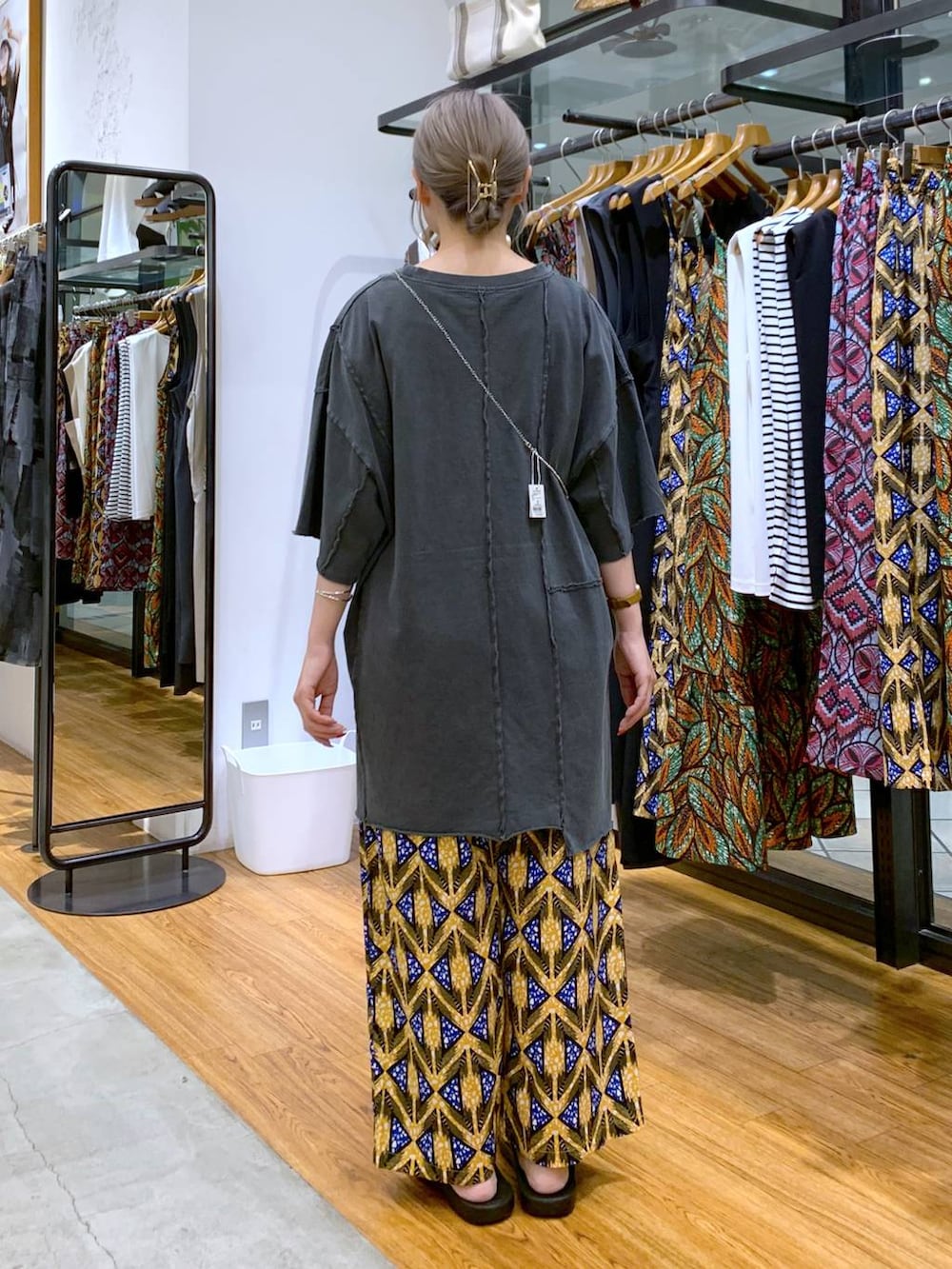 ブラック系のサンダル、グレー系のチュニック、オレンジ系のその他パンツを着用したレディースの夏コーディネートの2枚目の写真