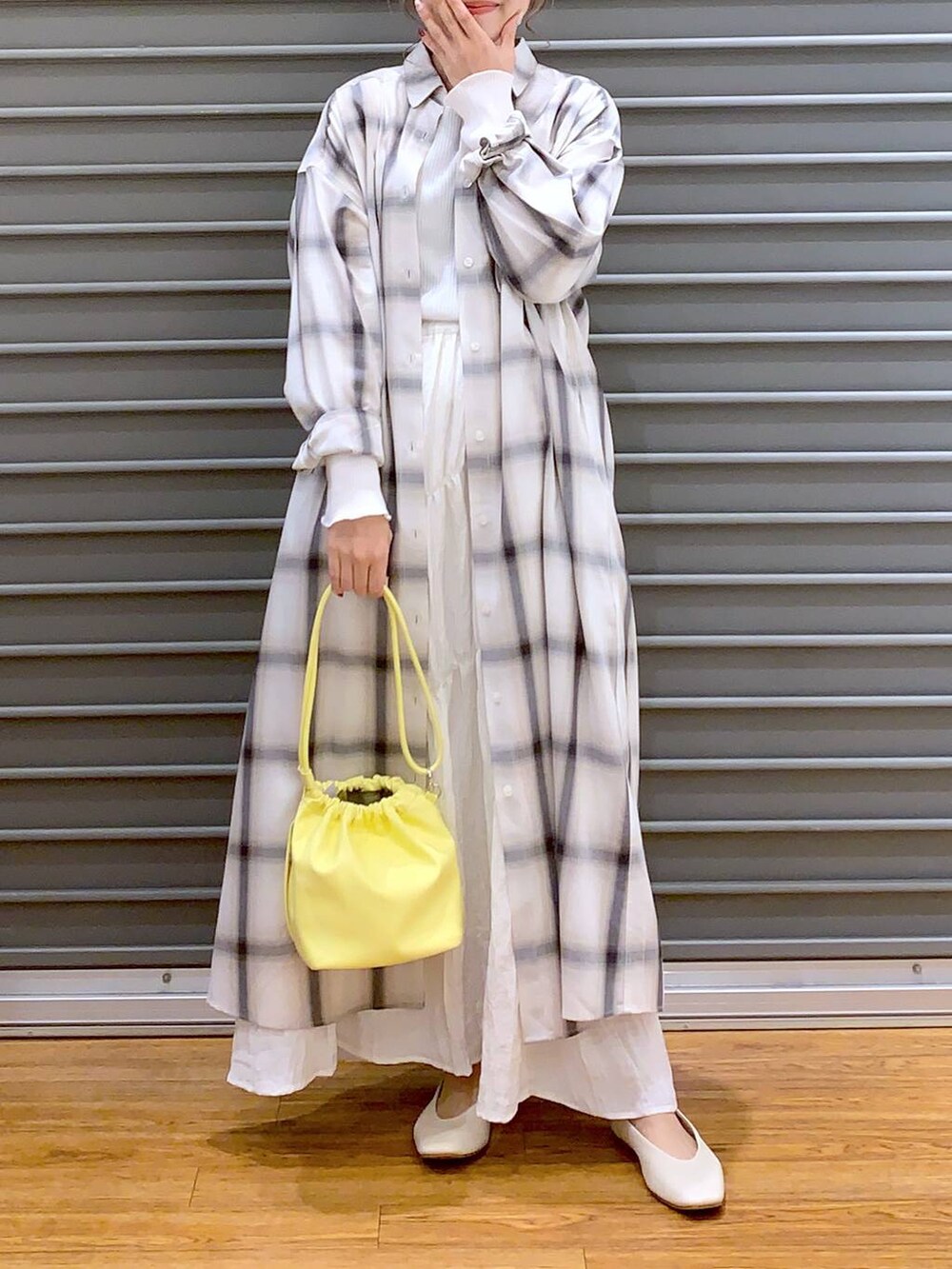 イエロー系のショルダーバッグ、ホワイト系のパンプス、ホワイト系のTシャツ/カットソーを着用したレディースの春コーディネートの6枚目の写真