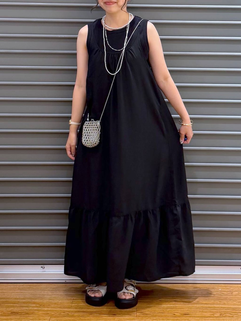 ブラック系のワンピース、ホワイト系のサンダル、ブラック系のタンクトップを着用したレディースの夏コーディネートの4枚目の写真