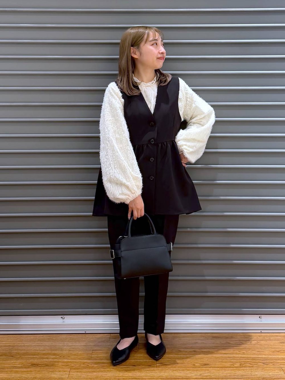 ブラック系のその他パンツ、ブラック系のその他アウター、ベージュ系のシャツ/ブラウスを着用したレディースの冬コーディネートの5枚目の写真