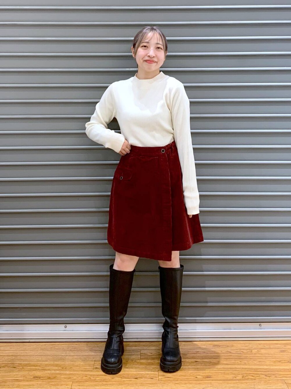 ホワイト系のポンチョ、ホワイト系のニット/セーター、ブラック系のブーツを着用したレディースの冬コーディネートの4枚目の写真