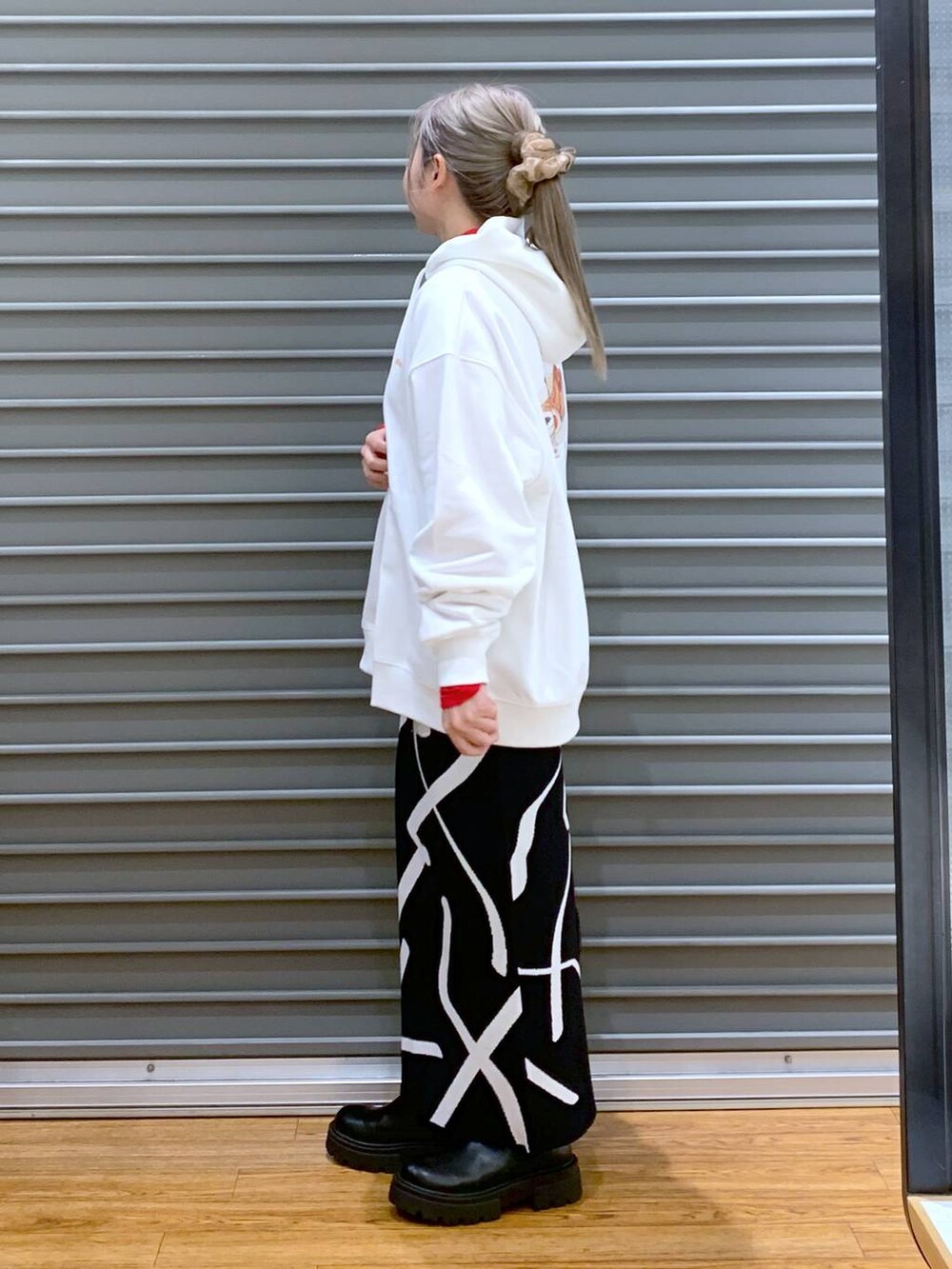 ブラック系のスカート、ブラック系のショルダーバッグ、ブラック系のブーツを着用したレディースの冬コーディネートの3枚目の写真